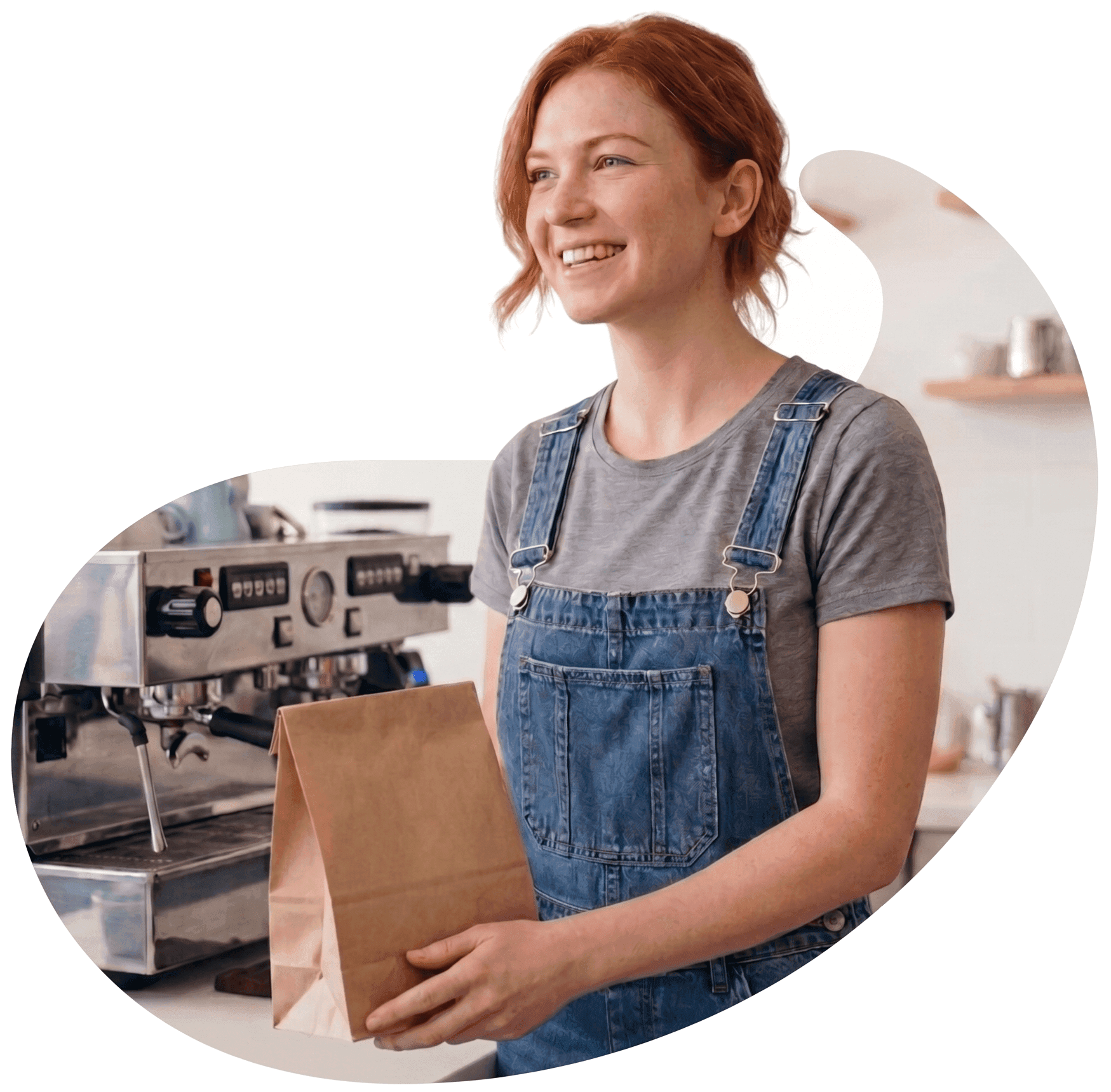 A smiling café owner holding a takeaway bag